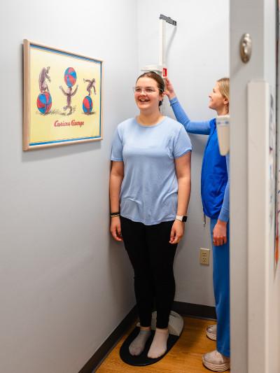 a teenage girl getting her height measured